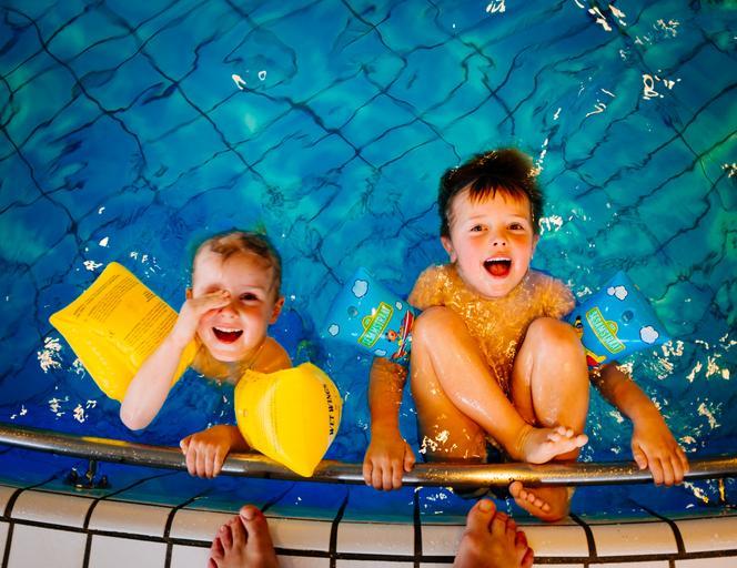 dvě malé děti koupající se v bazénu